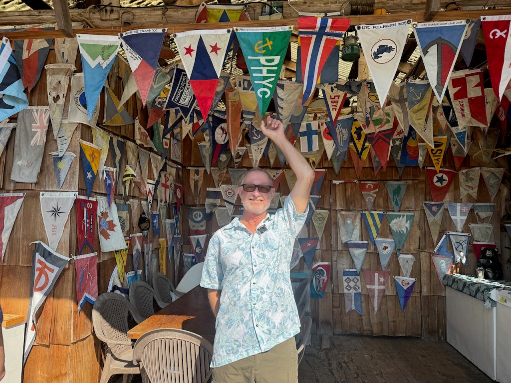 David beneath Pleasant Yacht Club's burgee at Lagoon Cove.